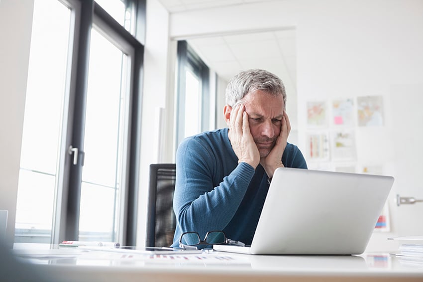 Hombre mirando fijamente la pantalla de un portátil